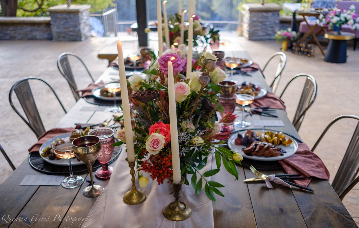 Table set for six with beautiful linens and lit taper candles